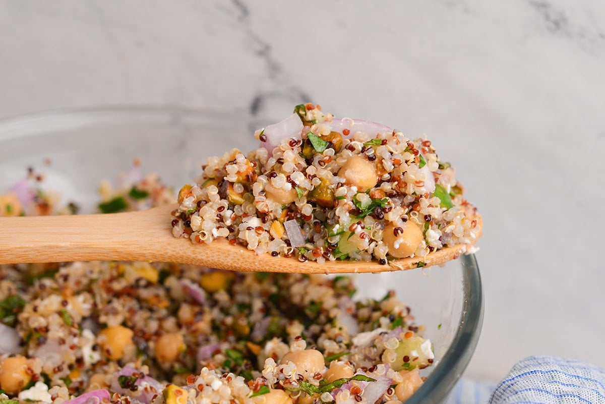 straight on shot of quinoa salad on wooden spoon