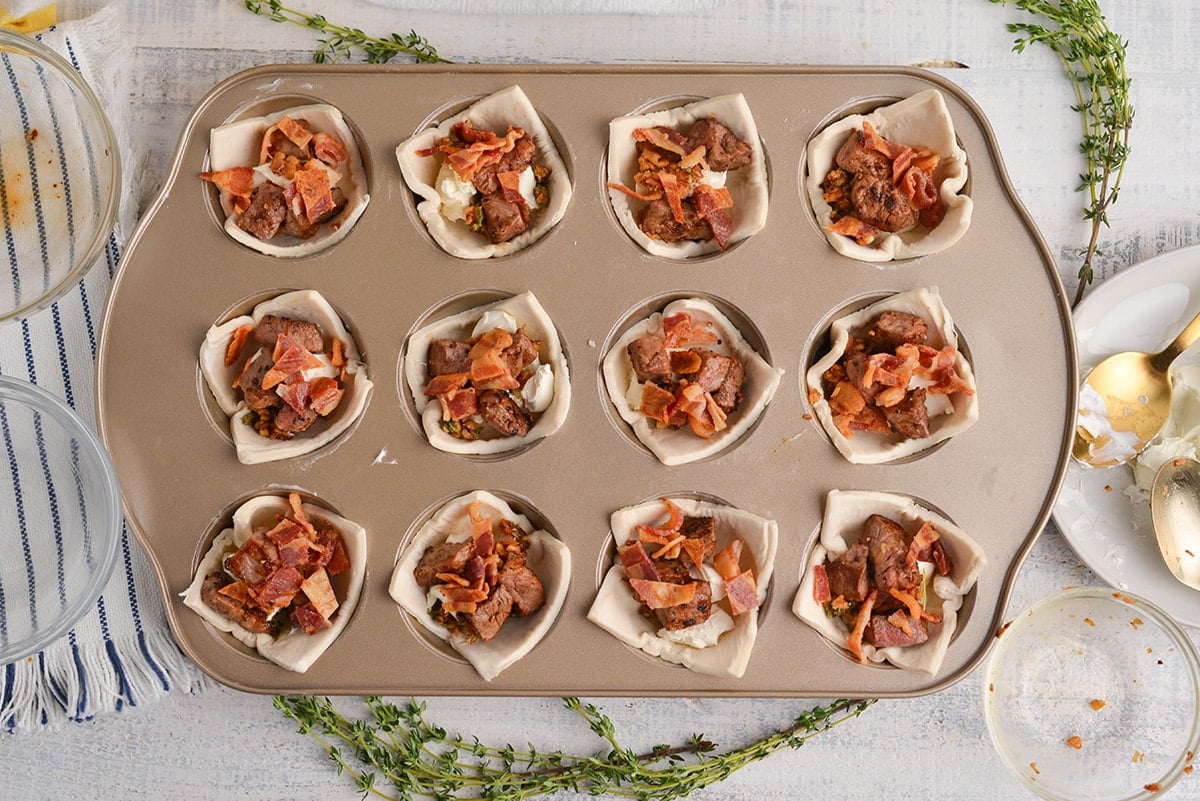 uncooked mini beef wellingtons in a muffin tin