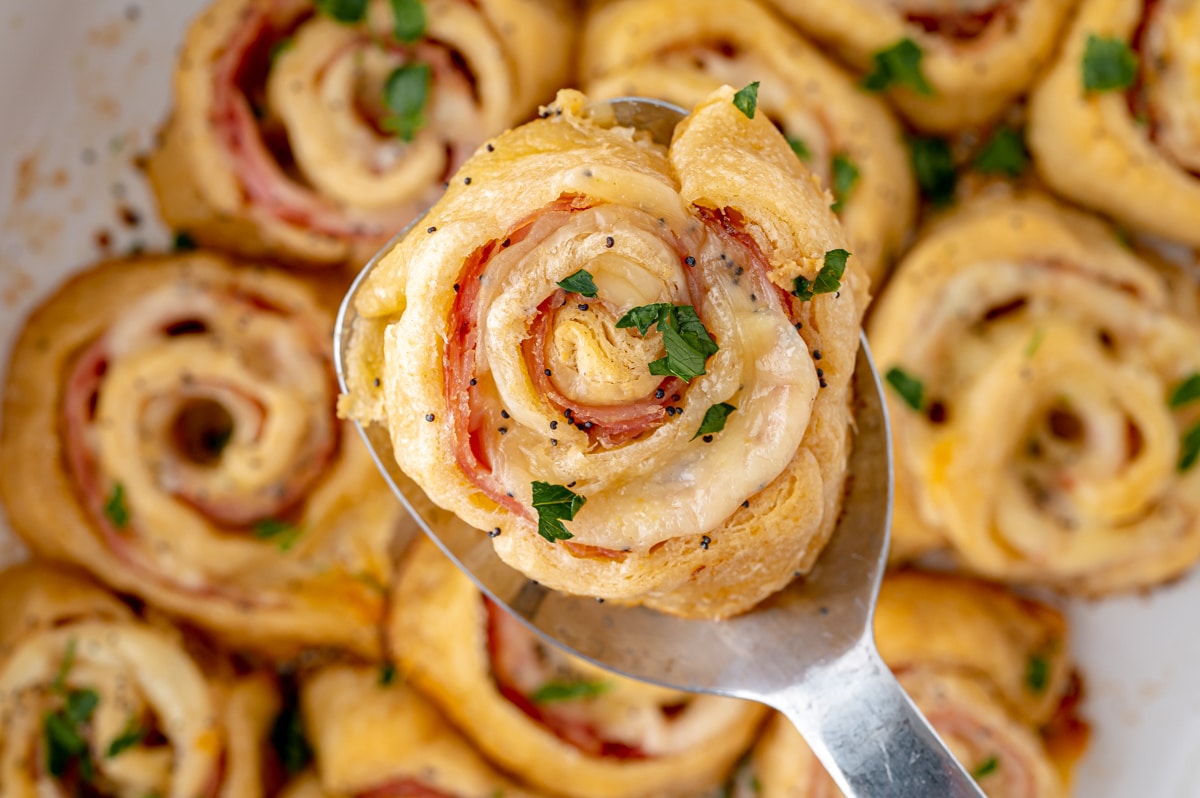 overhead shot of ham and cheese pinwheel on spatula