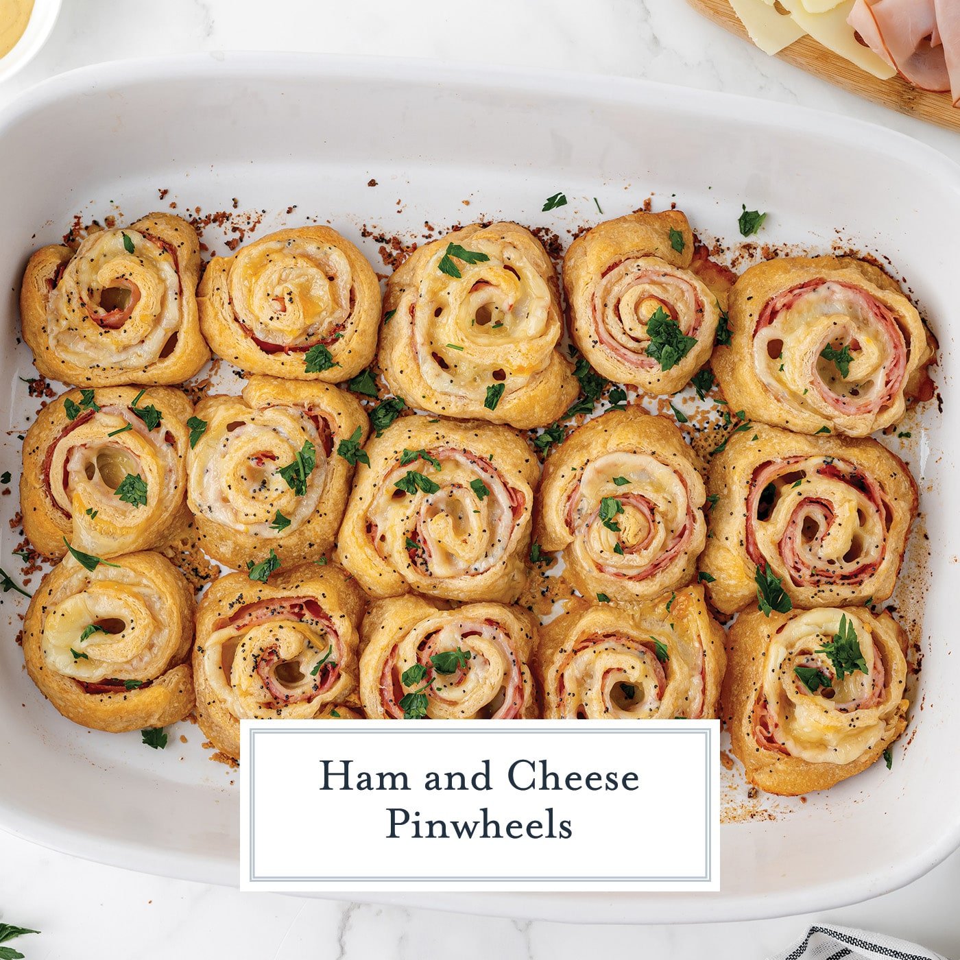 overhead shot of baking dish of ham and cheese pinwheels with text overlay for facebook