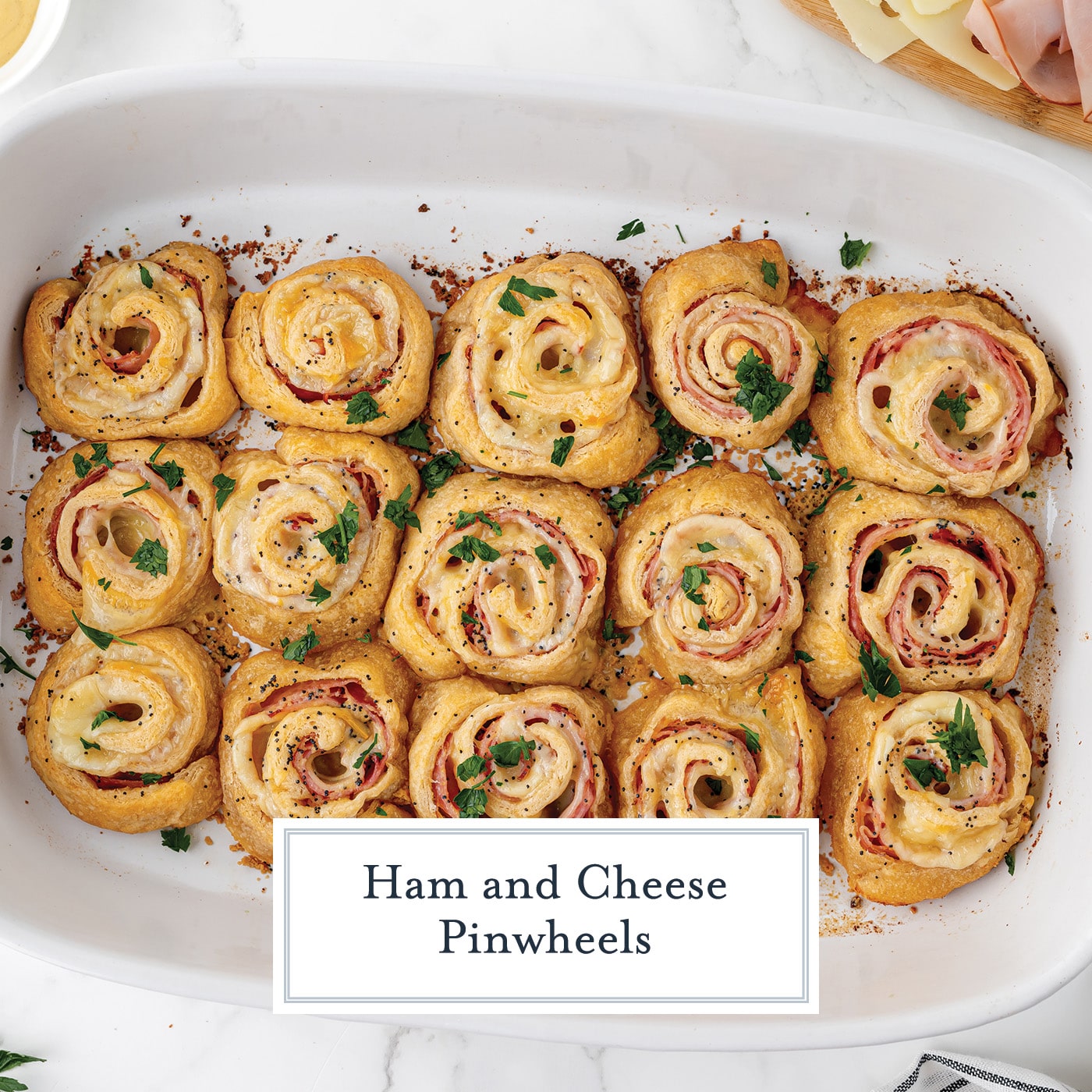 overhead shot of baking dish of ham and cheese pinwheels with text overlay for facebook