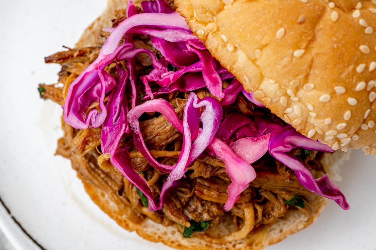 close up of red cabbage slaw on pulled pork sandwich