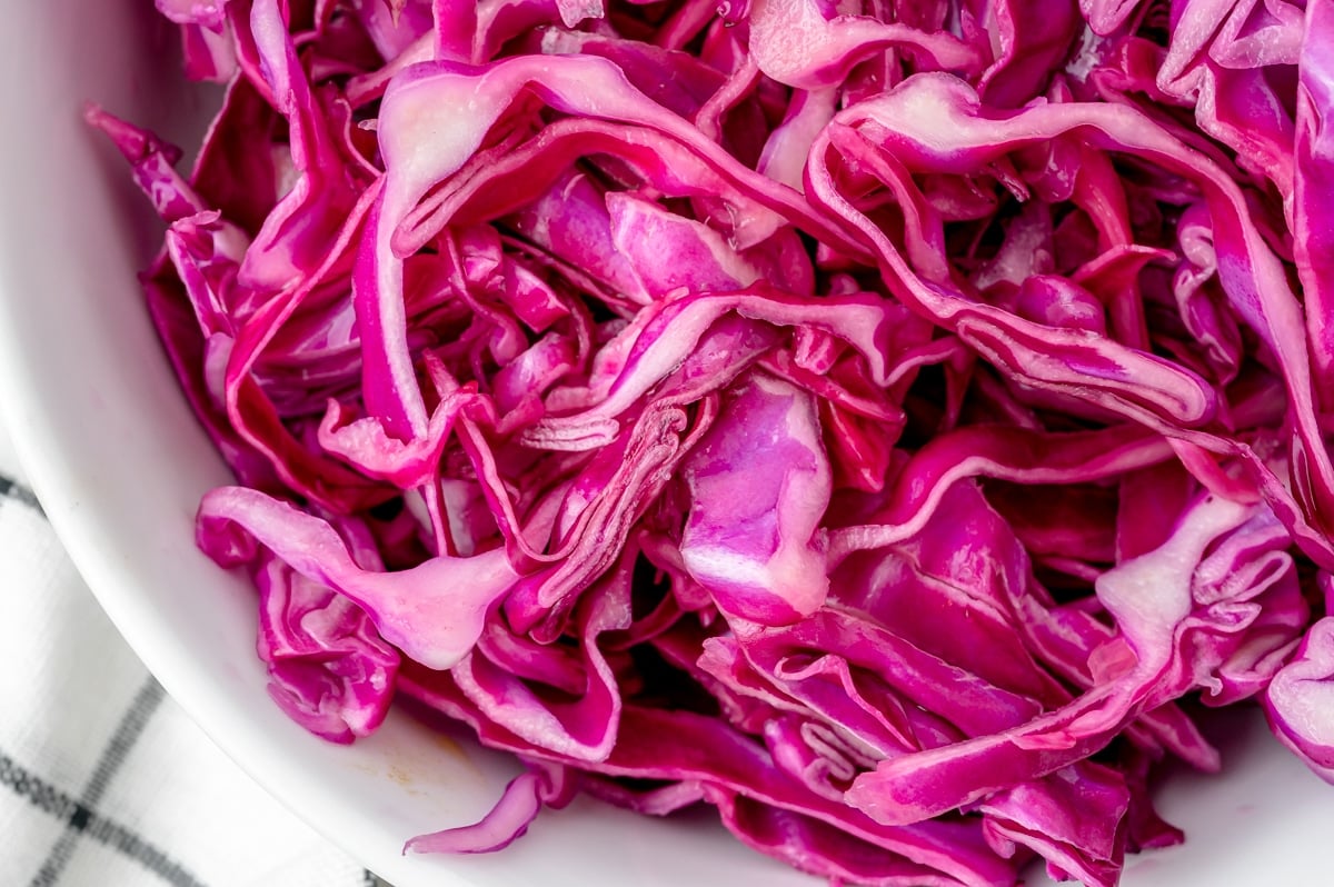 close up of red cabbage slaw in a white bowl