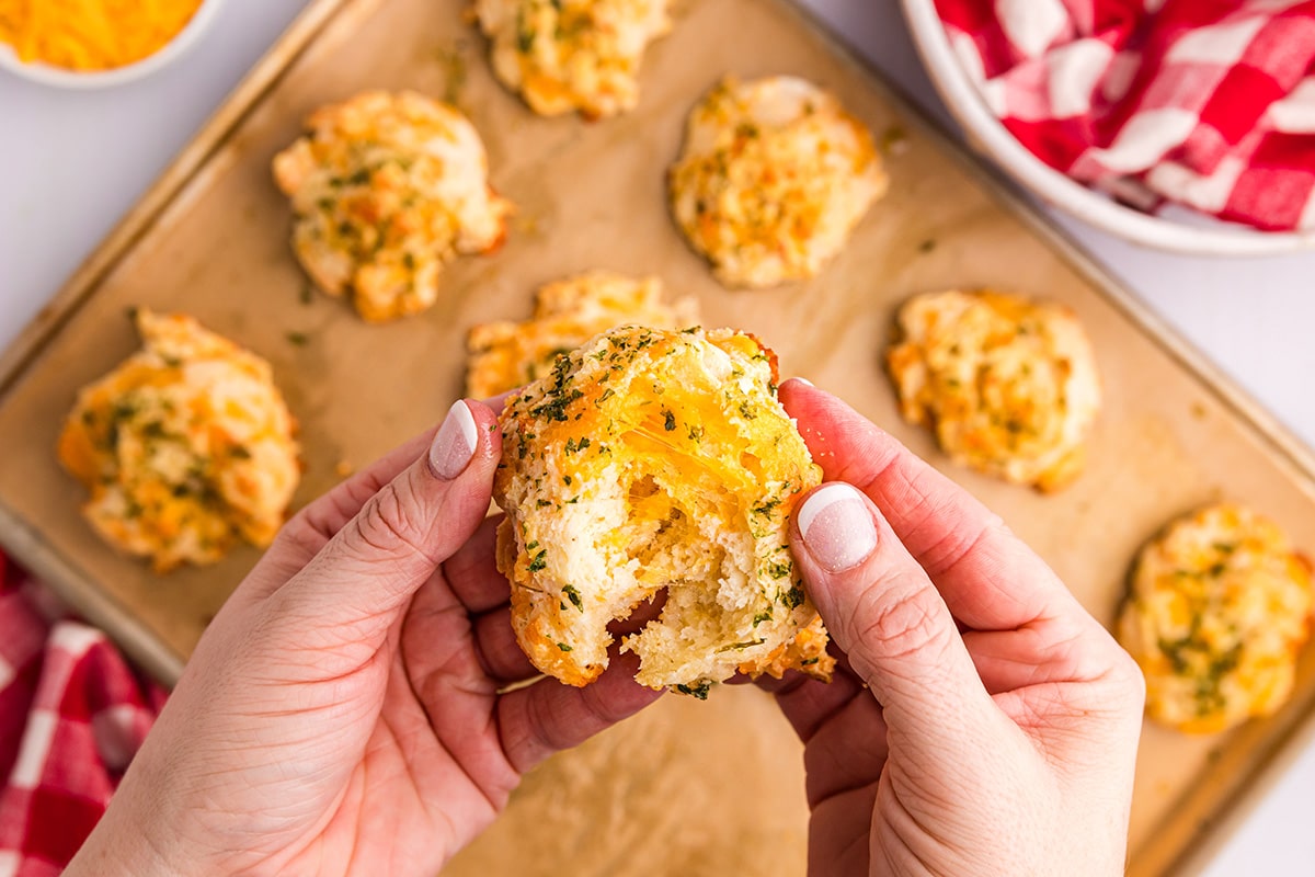 hands pulling apart red lobster biscuits