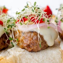 close up angle view of dressed sausage slider sandwich