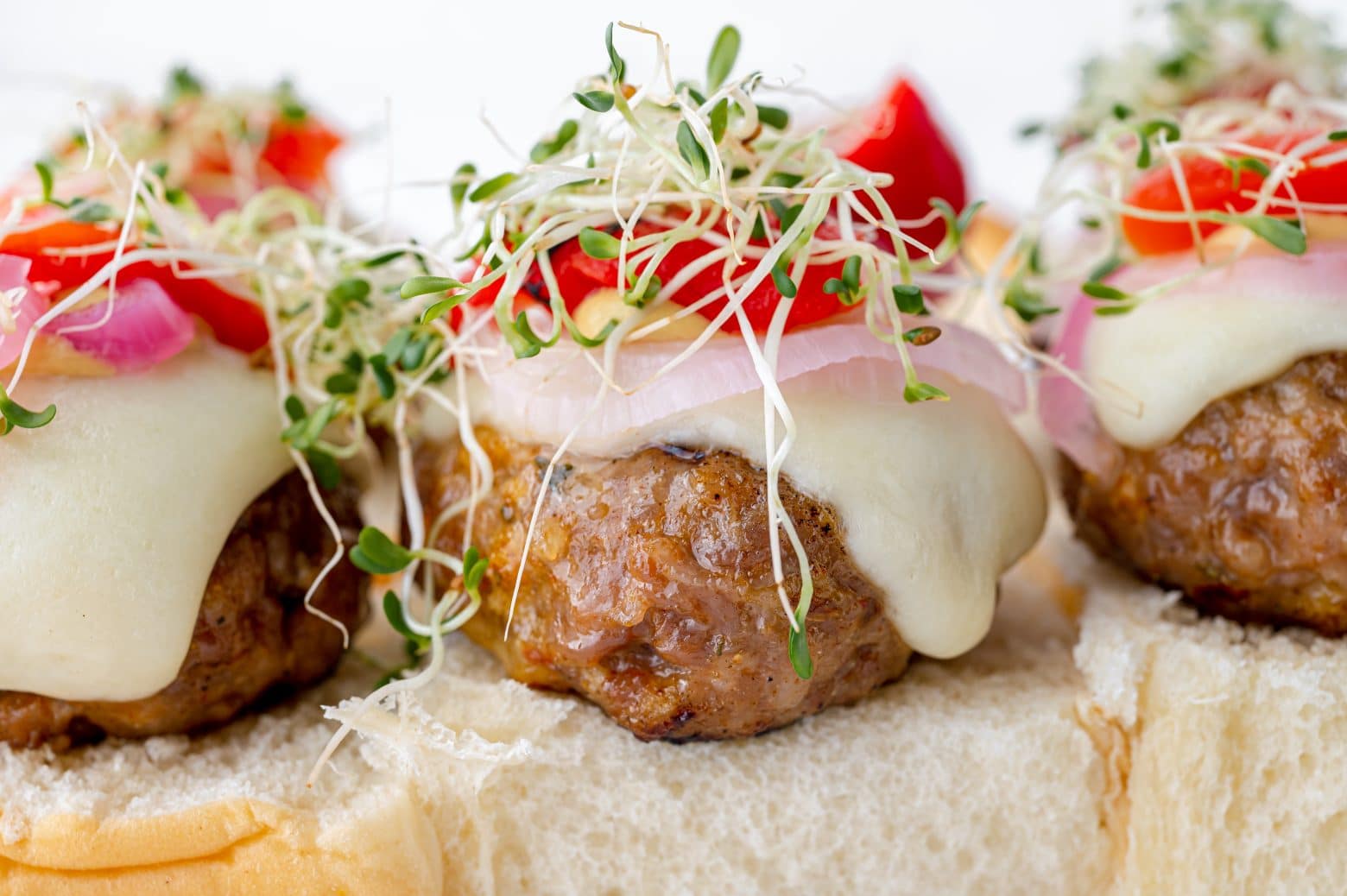 close up angle view of dressed sausage slider sandwich