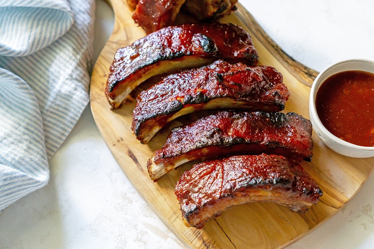 angled shot of sliced slow cooker ribs on a cutting board