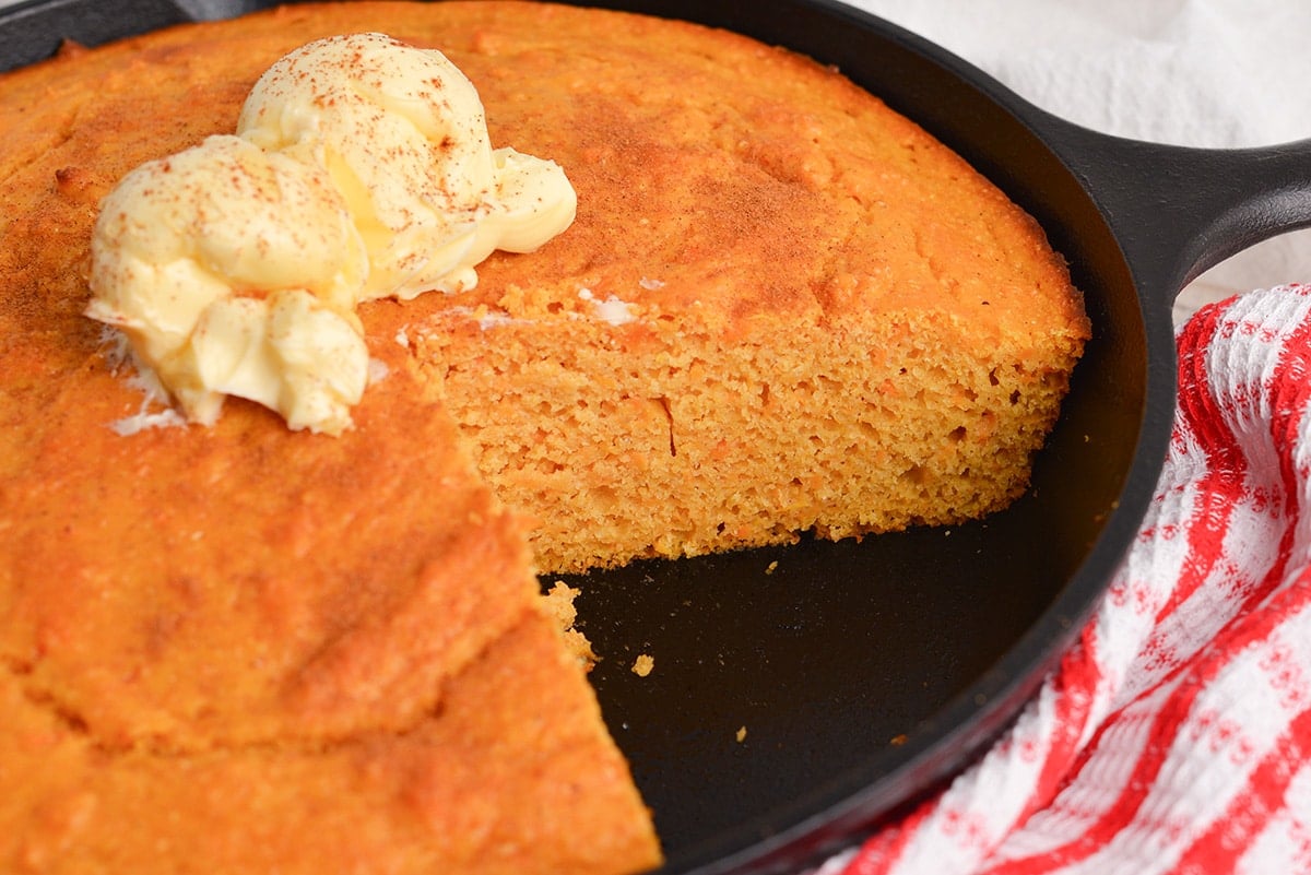 slice taken out of skillet of cornbread