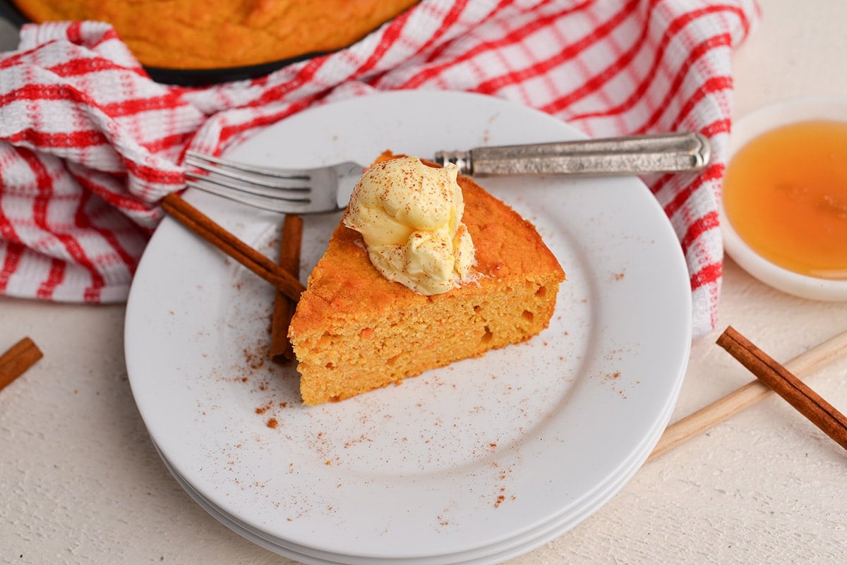 angled shot of slice of sweet potato cornbread topped with butter