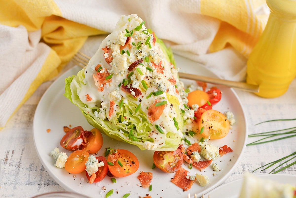 angled shot of wedge salad on plate with tomatoes