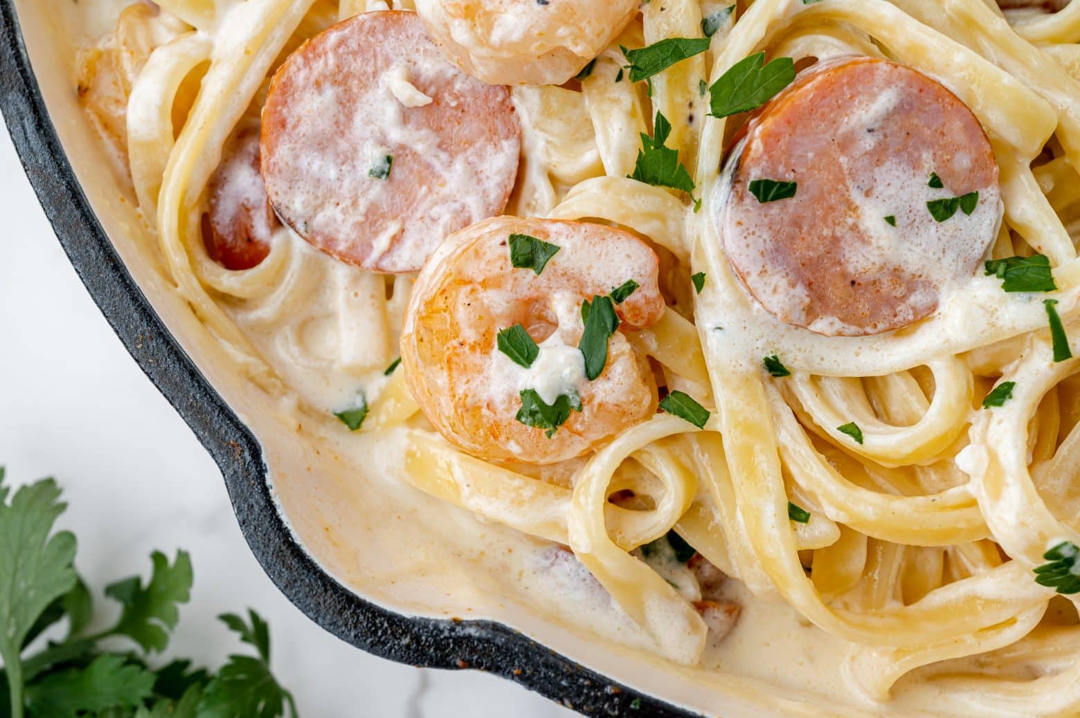 close up of shrimp and sausage in white cream sauce