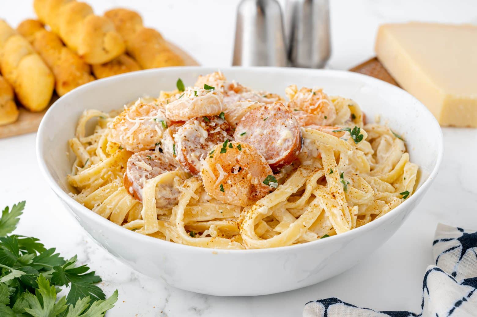 angle view of cajun shrimp alfredo in a white serving bowl