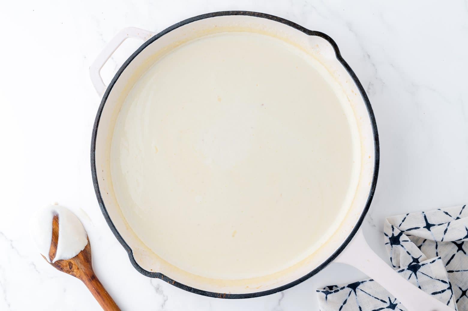 white alfredo sauce in a white pan