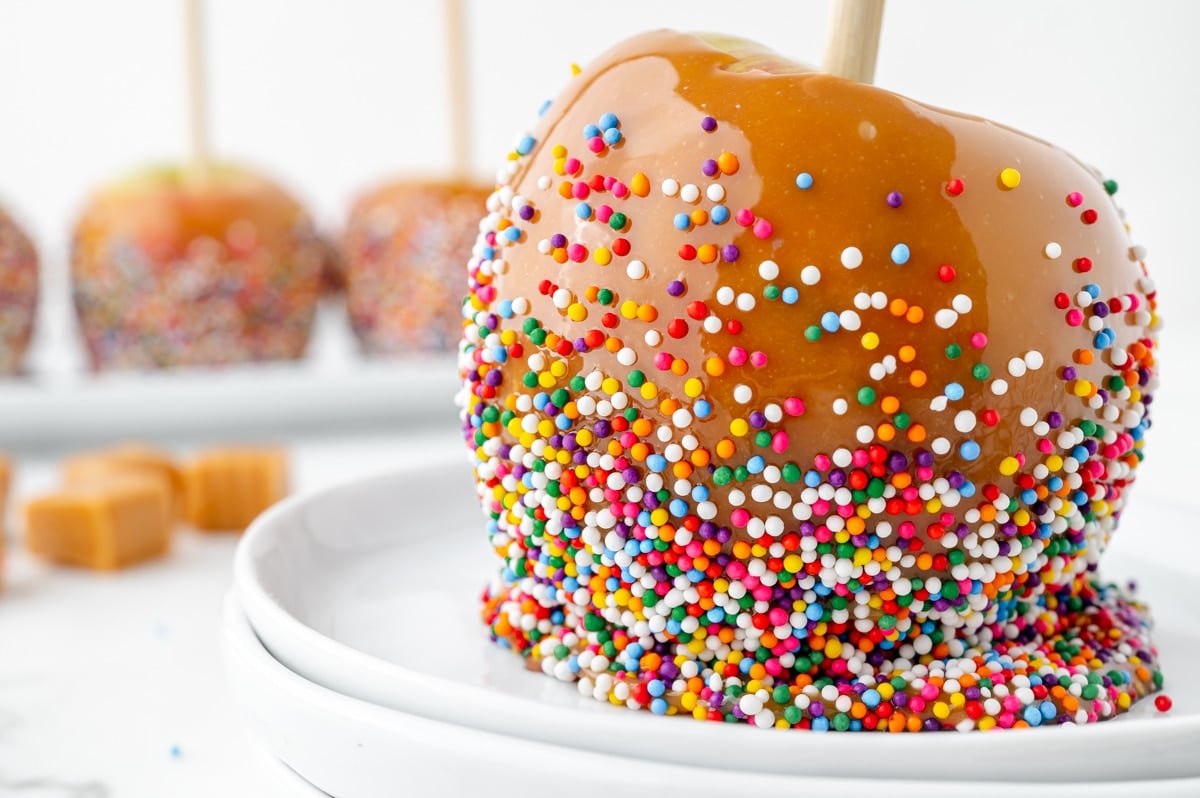 straight on shot of caramel apple coated with sprinkles
