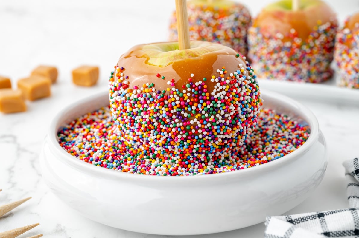 angled shot of apple in bowl of sprinkles