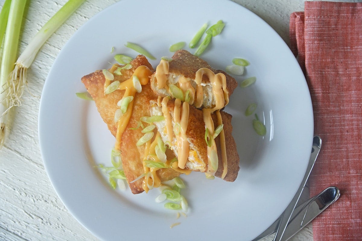 overhead shot of crab cake egg rolls on white plate