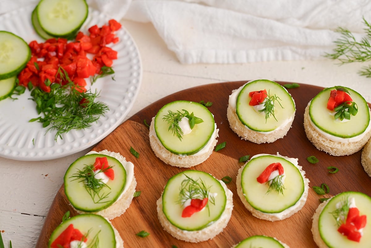 angled shot of cucumber canapes on a wooden board