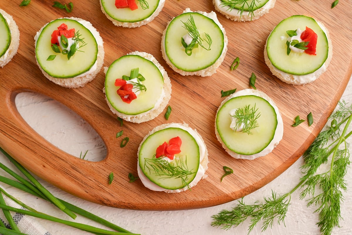 close up overhead shot of cucumber canapes on a wooden board