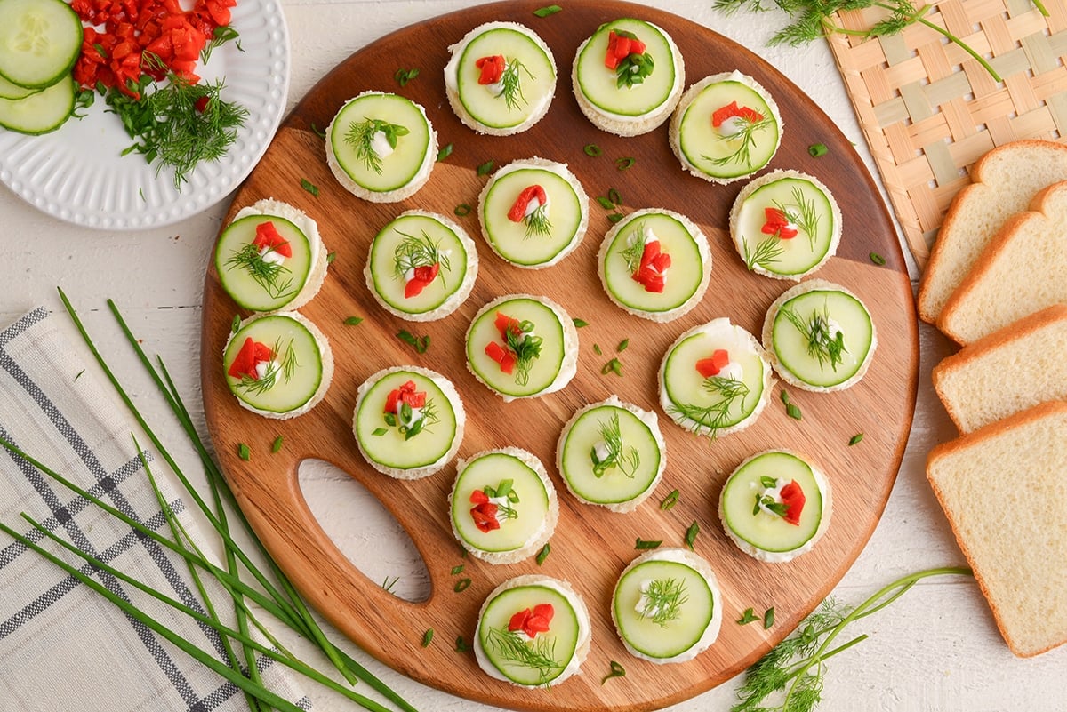 overhead shot of cucumber canapes on a wooden board