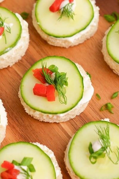 close up angled shot of cucumber sandwiches on a board