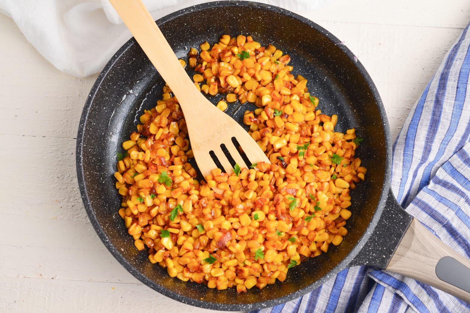 overhead shot of wooden spoon in pan of southern fried corn