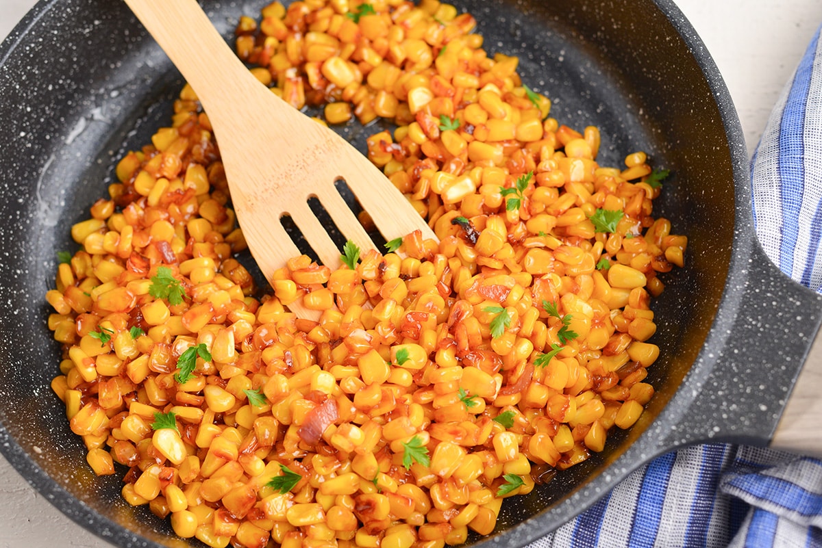 angled shot of wooden spoon in pan corn