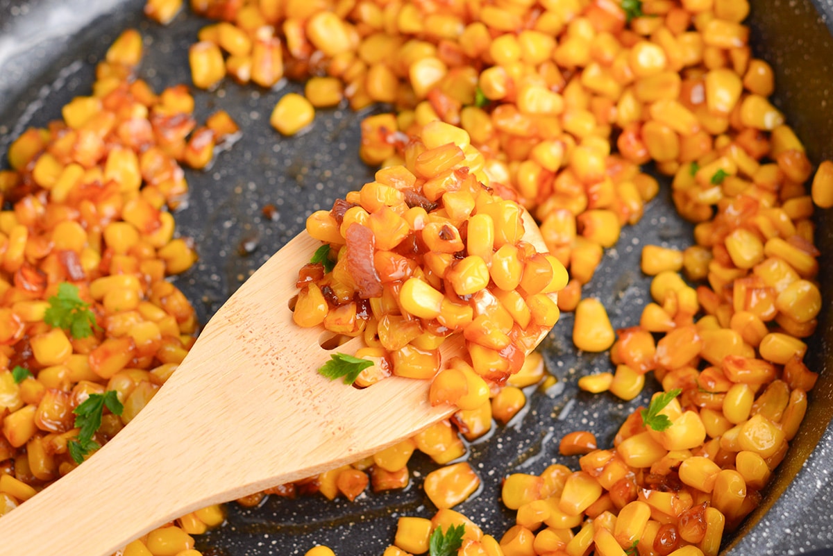 close up of wooden spoon with corn on it