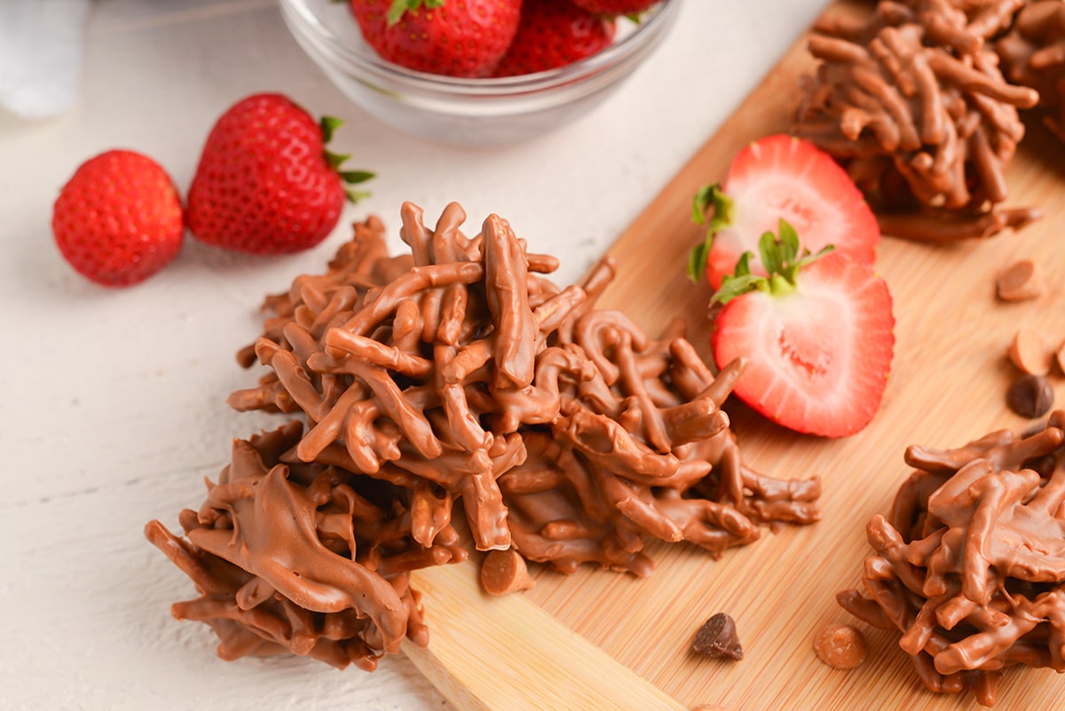 close up shot of haystack cookies with strawberries on cutting board