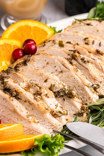 angled shot of platter of roast turkey breast with oranges and cranberries