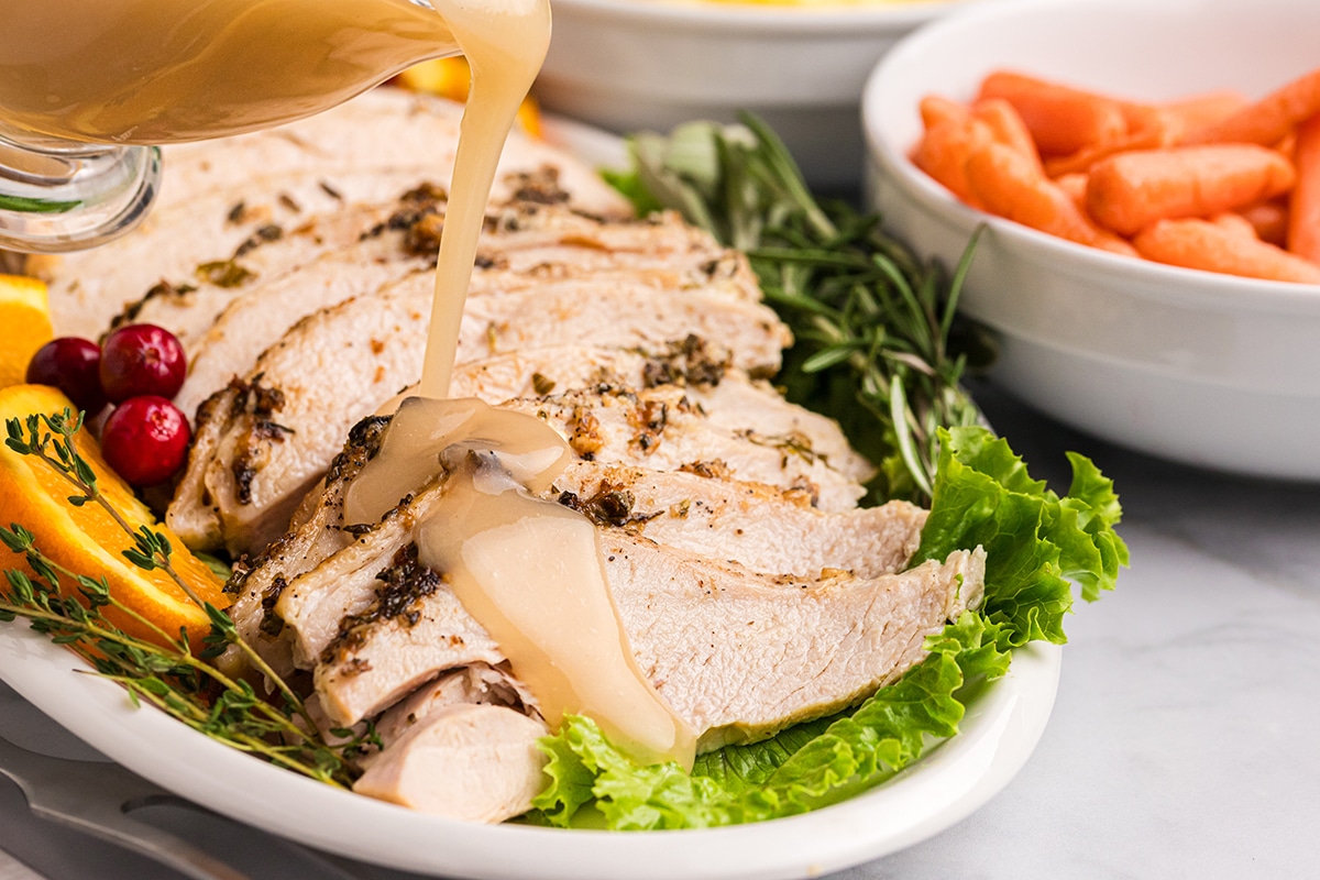 angled shot of gravy poured into sliced turkey