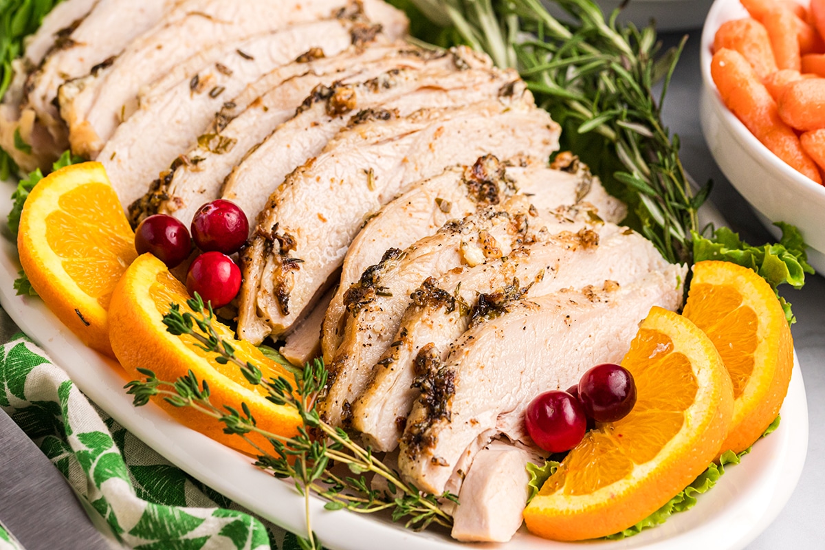 angled shot of platter of sliced herb mayo turkey breast