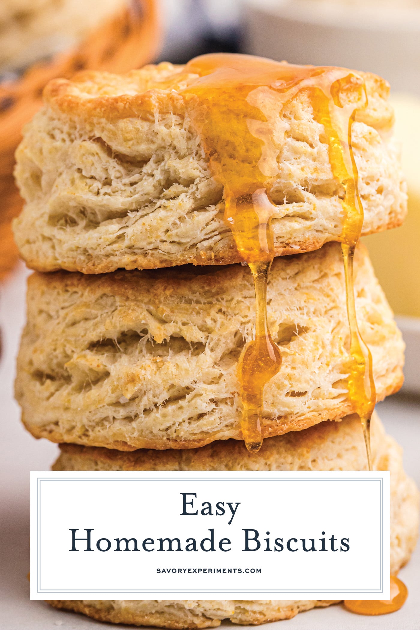 close up of a stack of biscuits with honey drizzling down the side