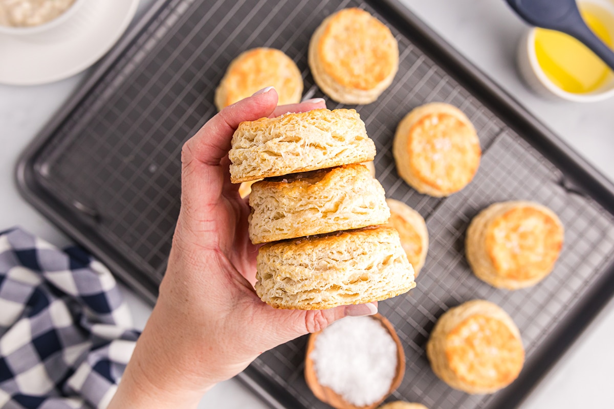 hand holding a stack of 3 biscuits