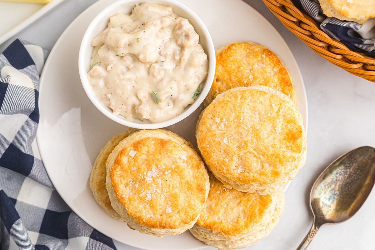 biscuits on a plate with side of creamy sausage gravy