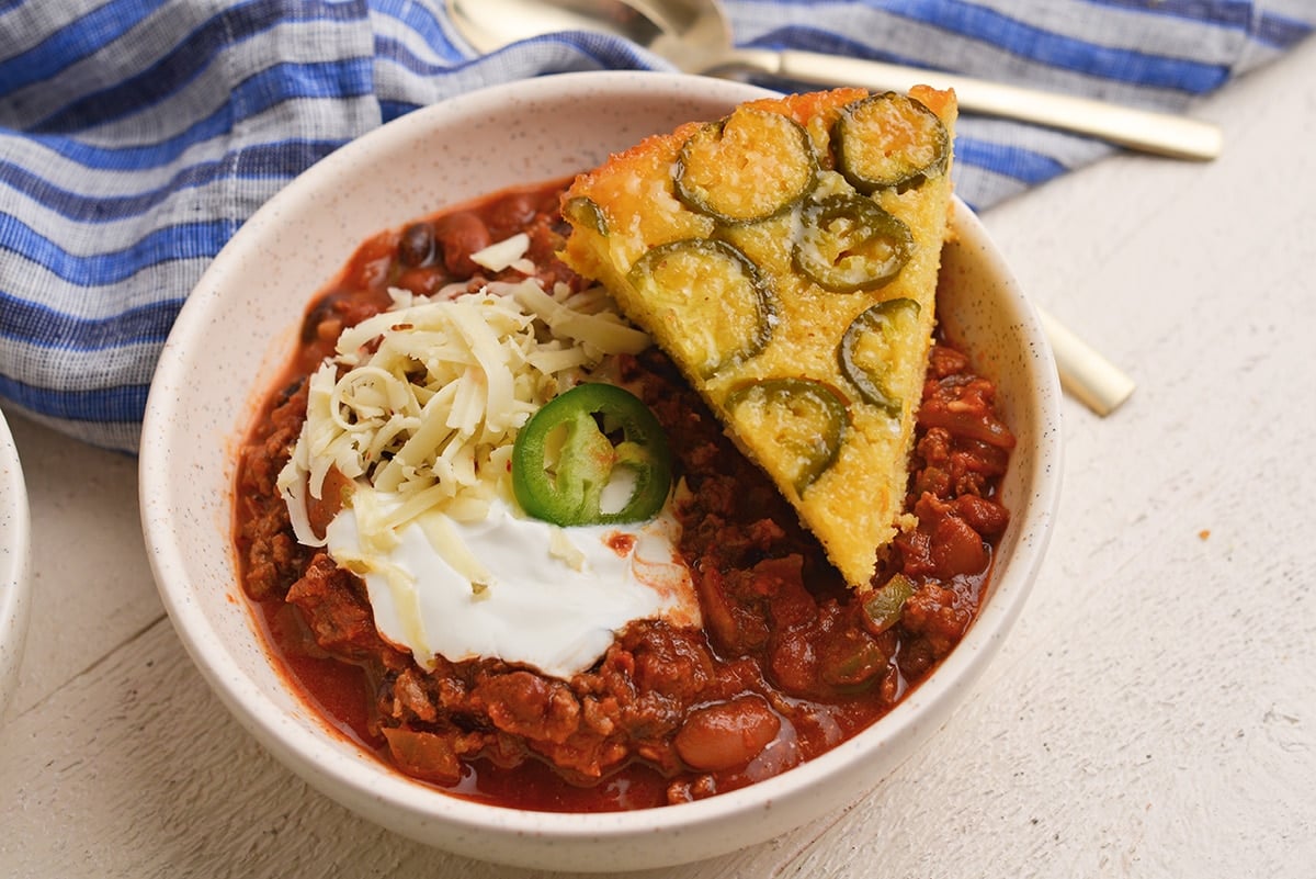 slice of cornbread in bowl of chili