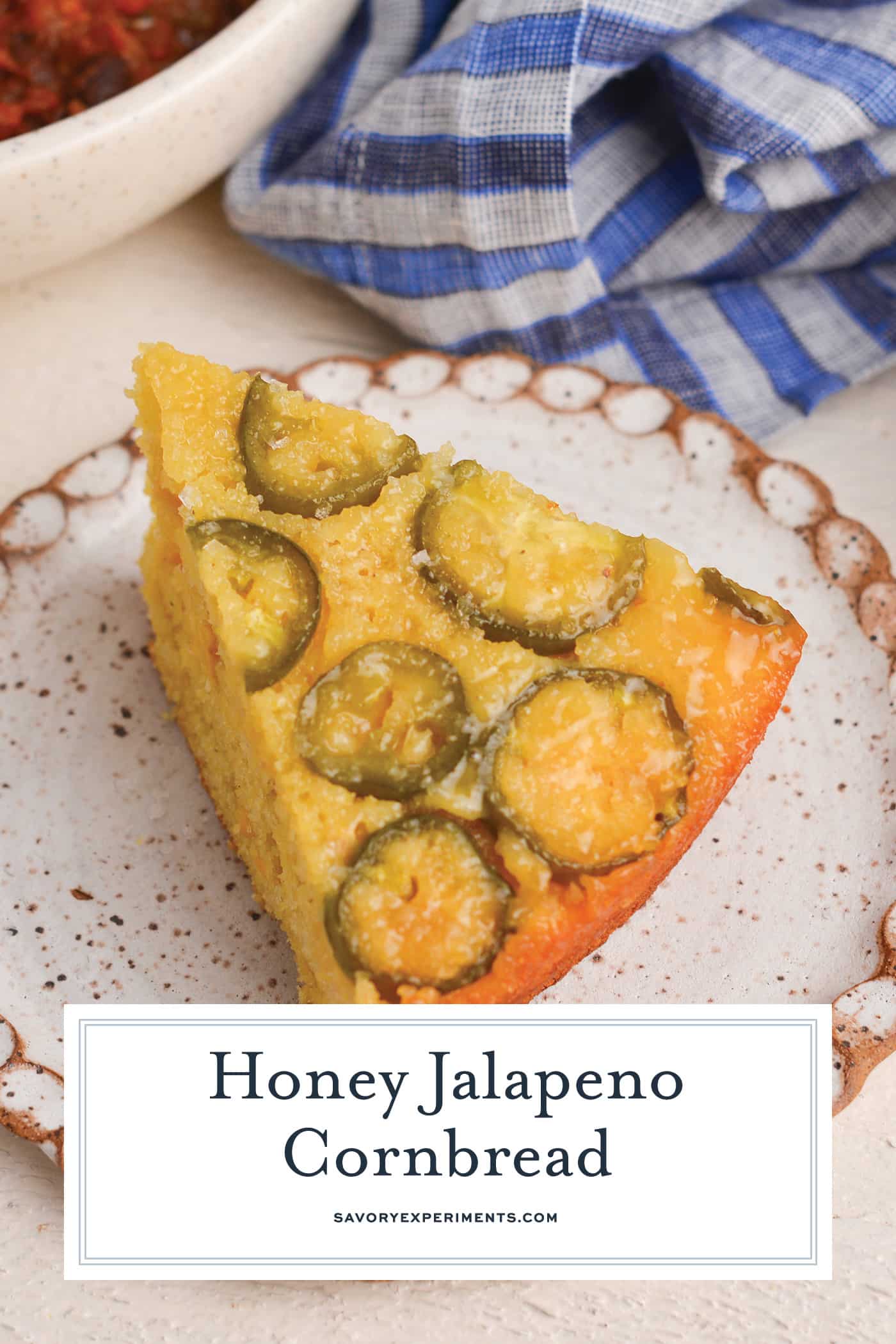 angled shot of slice of honey jalapeno cornbread with text overlay for pinterest