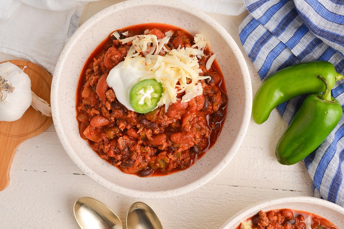 overhead shot of bowl of chili with sour cream and cheese