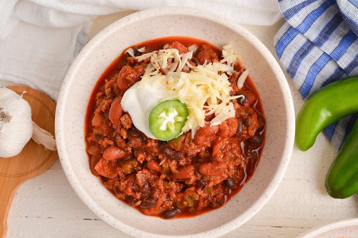 overhead shot of bowl of chili topped with cheese and sour cream