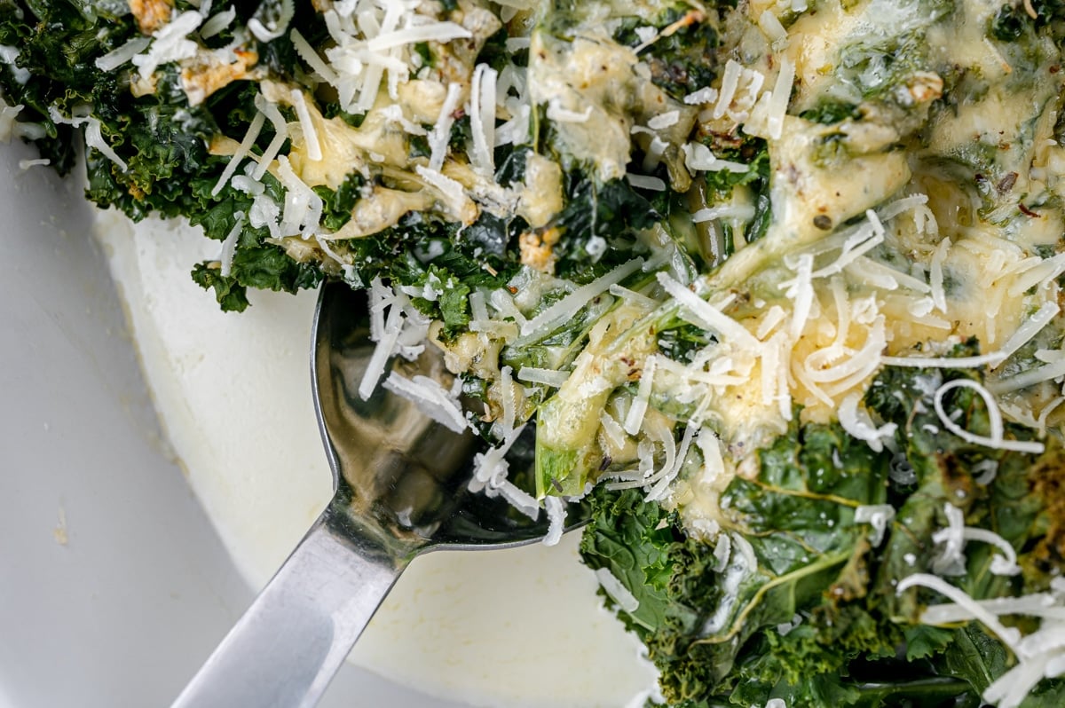 overhead shot of spoon scooping kale gratin from pan