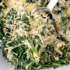 serving spoon scooping kale gratin from pan