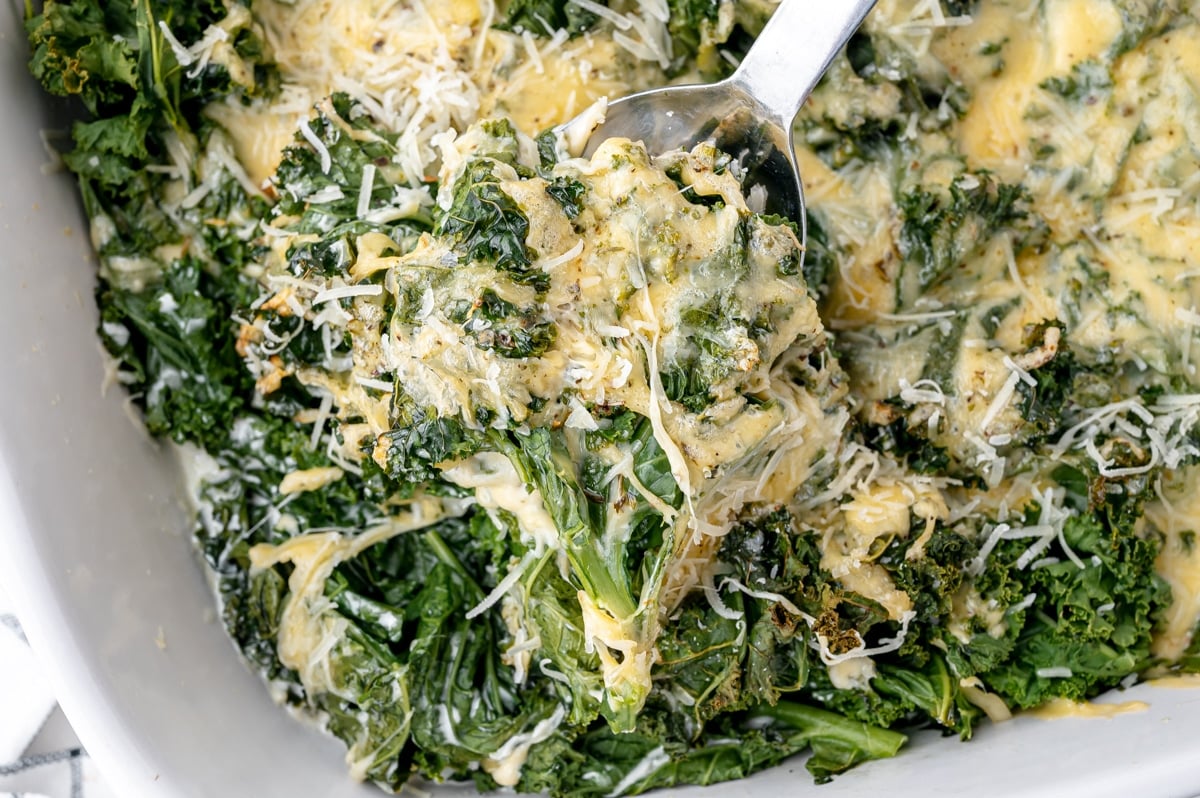 serving spoon scooping kale gratin from pan