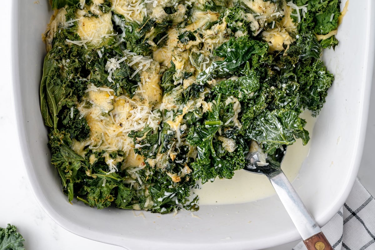 overhead shot of serving spoon in kale gratin baking dish