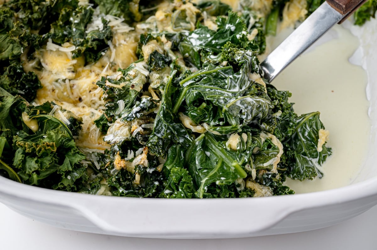 serving spoon in baking dish of kale gratin