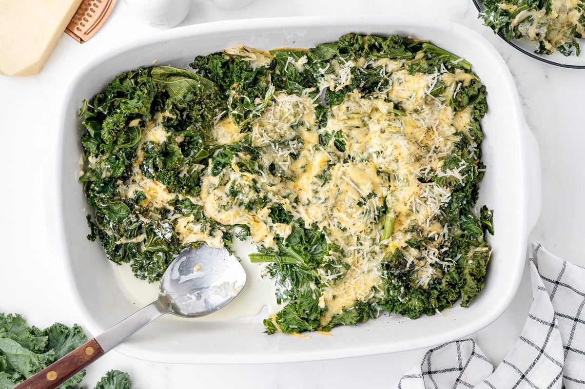 overhead shot of kale gratin in pan with serving spoon