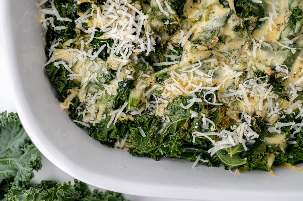 close up overhead shot of freshly grated cheese on baked kale gratin