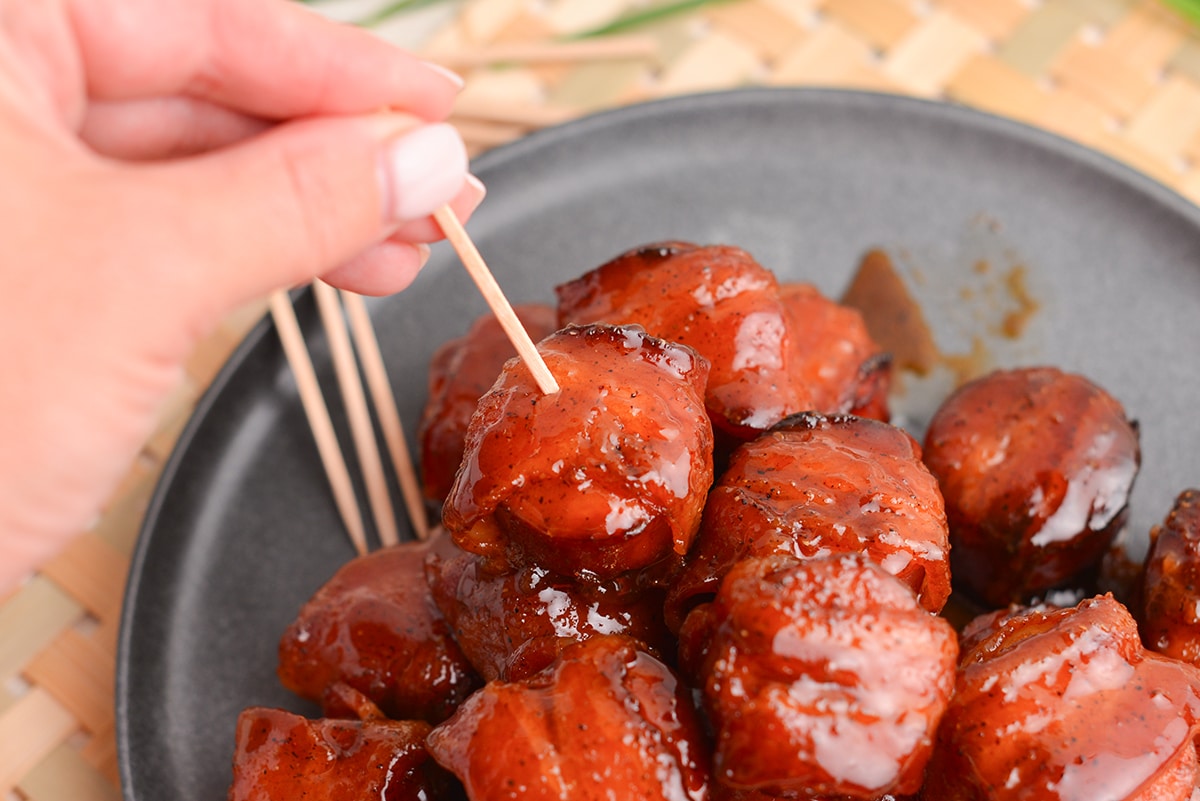 hand sticking toothpick into kielbasa bite