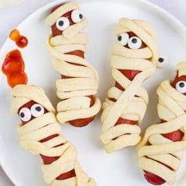 close up overhead shot of four mummy hot dogs on plate