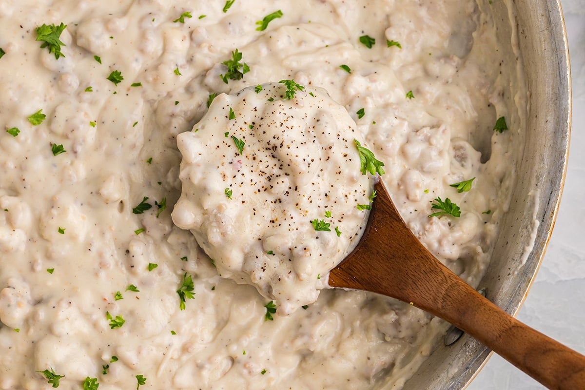 close up overhead shot of wooden spoon in pan of gravy