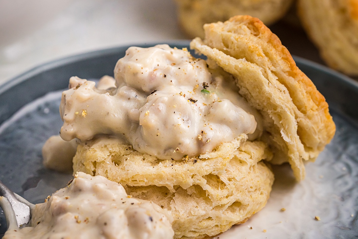 close up angled shot of sausage gravy on biscuit