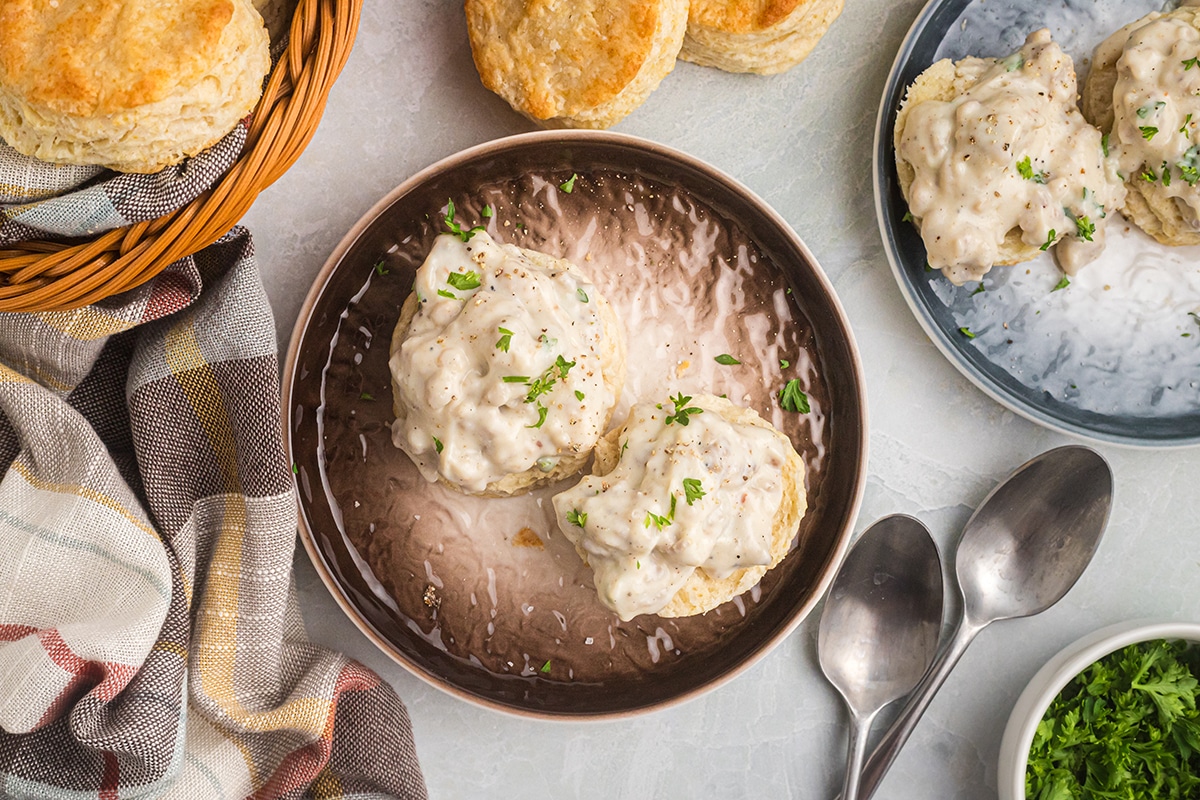 overhead shot of two biscuits on a plate topped with gravy